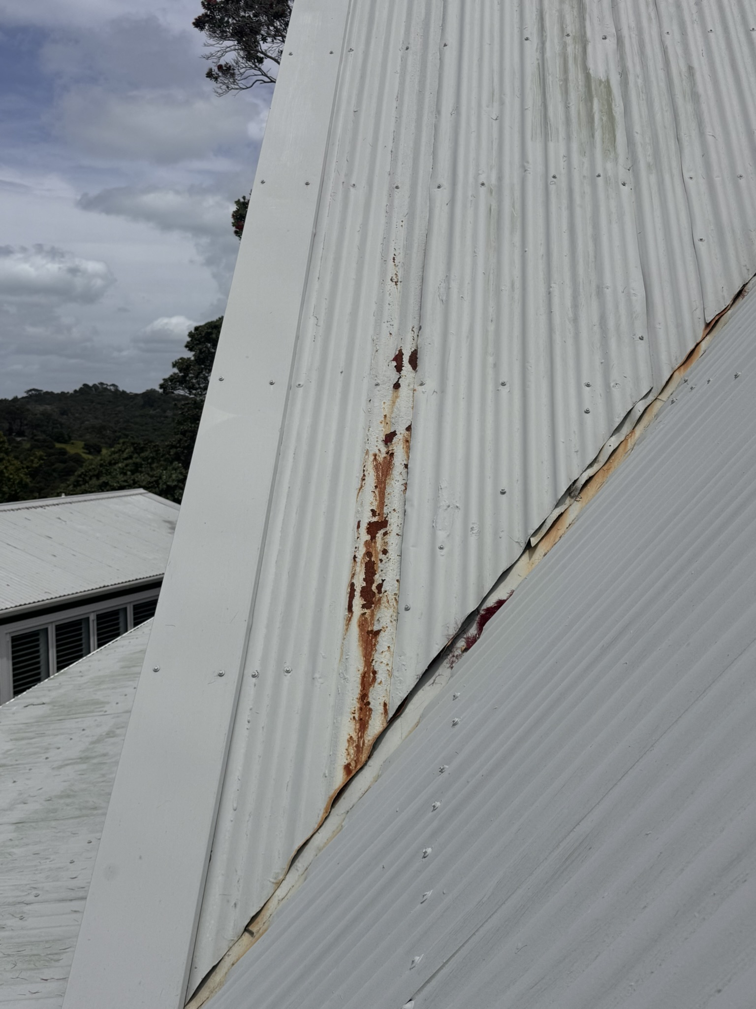 Corrosion and restricted clearance at a metal roof valley