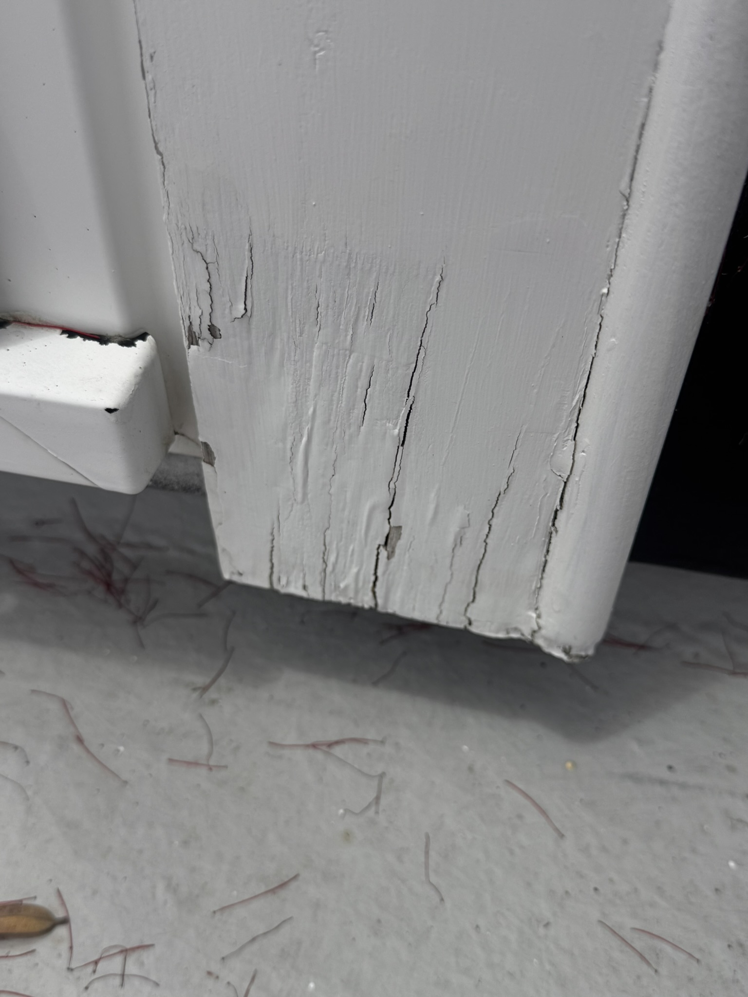 Cracking and decay at the base of a painted timber window facing